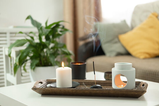 Scented candles and aroma incense sticks on table in living room. Aromatherapy, home fragrance. Concept of home relaxation and anti stress.