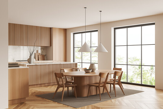 Light kitchen interior with eating zone and countertop, panoramic window