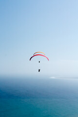 Paragliders in unison against a clear sky