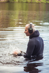 man underwater with a metal detector in headphones