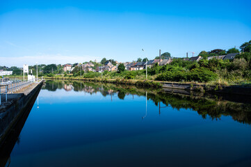Fototapeta na wymiar Namur, Wallon Region, Belgium, Industrial banks of the River Sambre reflecting in the blue water