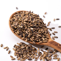 Thistle seeds in a wooden spoon on a white background, square format