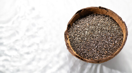 Chia seeds in coconut bowl on water surface with waves, place for text, banner