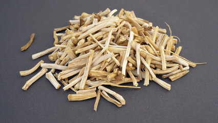 Close up of Ayurvedic herb Satavari or kurilo or Asparagus racemosus isolated on white in a glass bowl.