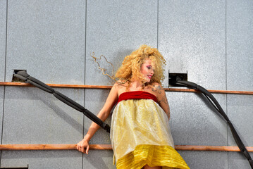 High fashion portrait of sophisticated blonde woman with curly hair on city rooftop outdoors. Urban...