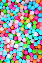 Multi-colored, highly saturated plastic balls, in soft play ball pit, at a child's play park. Colorful balloon.