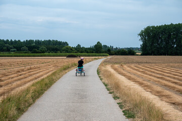 39 yo white woman with Down Syndrome driving her tricycle through the fields of Tienen