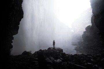 man under waterfall