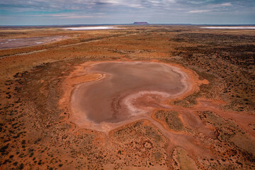 Aerial view of an Australia shaped salt lake in the Northern Territory with Mount Conner in the background