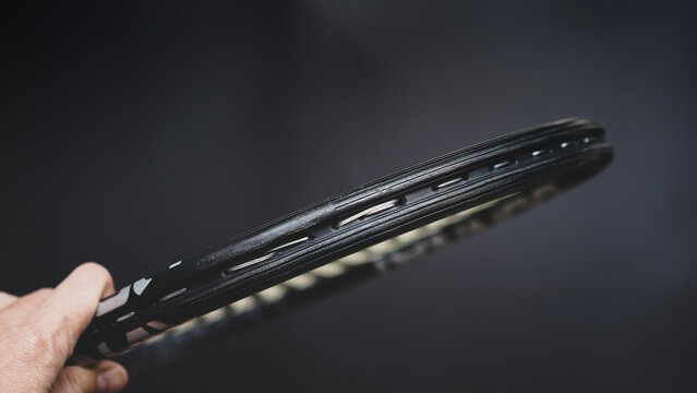 part of tennis racket head on black background, part of the game concept