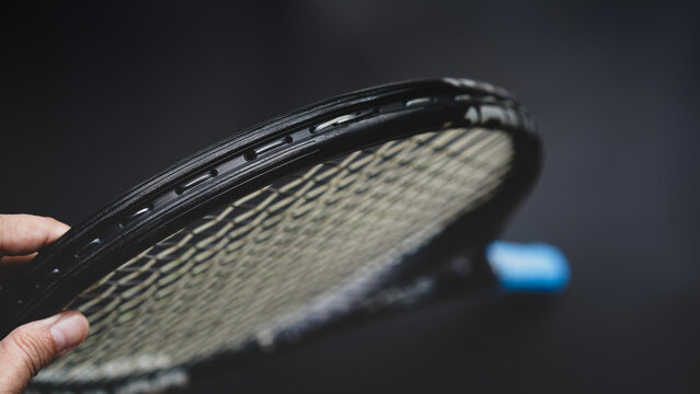 part of tennis racket head on black background, part of the game concept