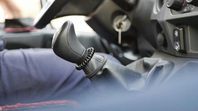 The driver's hand shifts the gear with a high-speed lever when driving and driving a car on a manual transmission. Close-up, slow motion