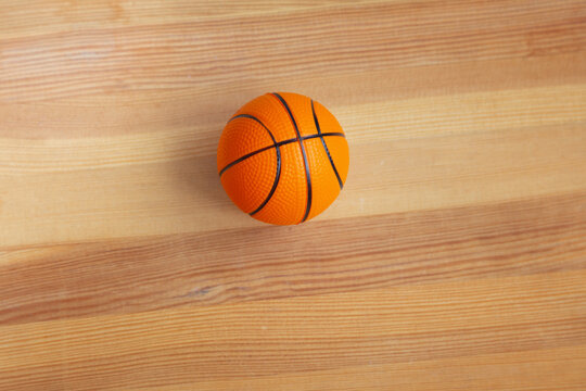 Basketball small ball close-up on a wooden parquet. Sports background with souvenir basketball.