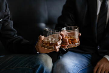 Close-up of serious businessman holding a glass of whiskey bar rest ideas and drinking alcohol