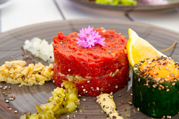 delicious tartare from beef with egg on ceramic plate. fresh beef tartar dish with tasty vegetables