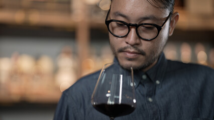 Night club concept of 4k Resolution. Asian man tasting wine in a restaurant. A group of specialized...