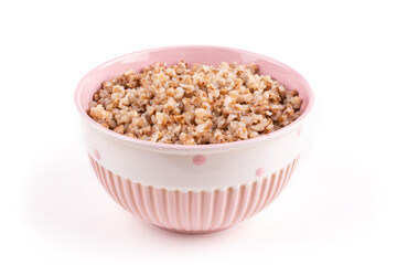 Buckwheat porridge in a pink bowl (plate) on a white isolated background. Porridge for a child (baby). Healthy breakfast, side dish. Template for the design.