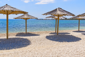 straw umbrellas on the beach. Empty beaches during quarantine. luxury beach. Pandemic warning, lack of tourists