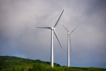 Two electric windmills in the top of a hill