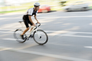 A blurry photo in motion. A cyclist and his bike, rides very fast.
