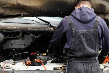 young male auto mechanic with overalls in car service, copyspace