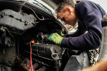 car engine diagnostics and repair, young male master auto mechanic.