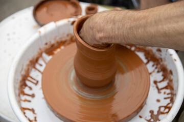 Man making ceramic pot..Master making clay pottery..Potter's hands working clay on a potter's wheel.