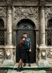 Fototapeta na wymiar Lovely couple posing near a black door. Lviv, Ukraine November 2, 2019