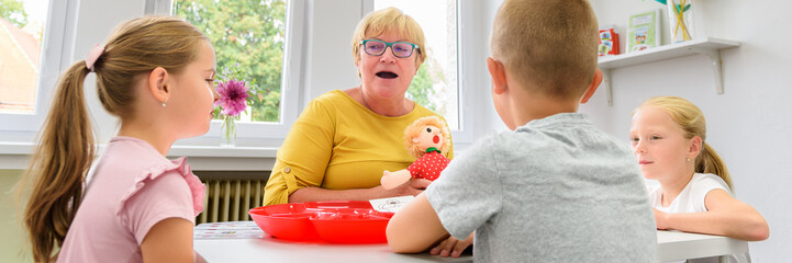 Children speech therapy concept. Children practicing correct pronunciation with a female speech...