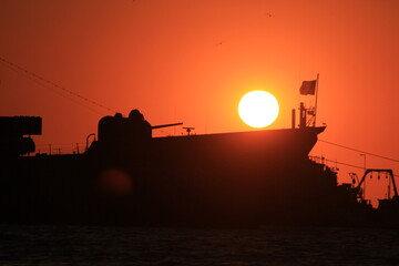 sunset over military ship