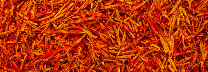 Naklejka premium Saffron spice, pistils and stigmas of a crocus flower close-up, flat lay as a background. Indian and Arabic spices for cooking. Medicinal herbs and spices.