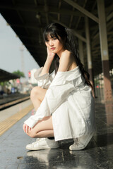 Portrait of thai japan adult beautiful girl white shirt blue jeans relax time, train station fashion