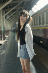 Portrait of thai japan adult beautiful girl white shirt blue jeans relax time, train station fashion