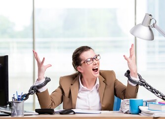 Woman chained to her working desk