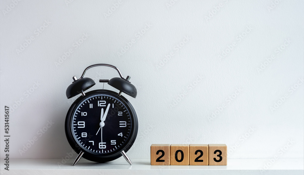Poster 2023 happy new year background. 2023 calendar number on wooden cube blocks with black alarm clock af