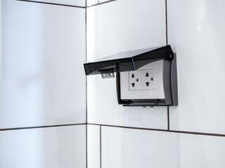 Close-up empty white electrical plug socket plate panel with transparent plastic shield on tiles in...