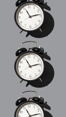 black alarm clock on gray background pattern