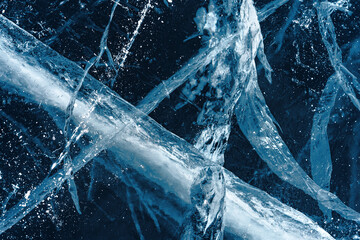 Transparent dark blue ice of frozen Baikal lake with white cracks pattern. Beautiful winter nature...
