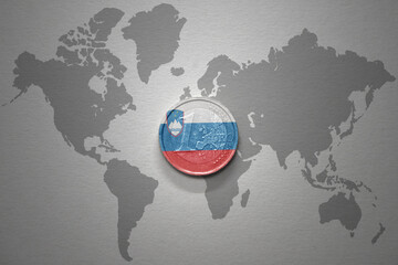 euro coin with national flag of slovenia on the gray world map background.3d illustration.