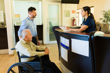 Nurse giving admission information about check in at the nursing home - obrazy, fototapety, plakaty