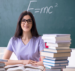 Young female teacher student in front of green board