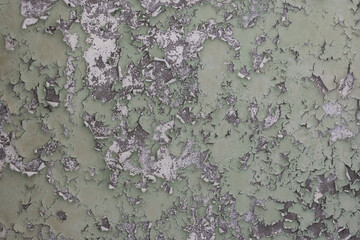 Peeling paint on the wall. Old concrete wall with cracked flaking paint. Weathered rough painted surface with patterns of cracks and peeling. High resolution texture for background and design. Closeup