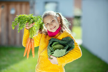 Happy teen girl with his fresh vegetables in yellow pullover excited about her harvest