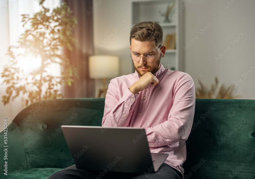 Poster handsome bearded man have work thoughts, using laptop for working with project from home, remote wor