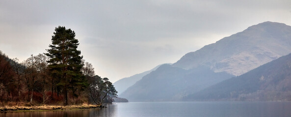 On a late March evening, gentle rain begins to fall on the reflective still surface of Loch Eck....