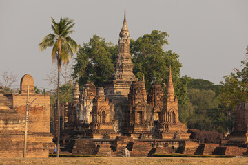 Wat Mahathat temple and pagodas of Thai style architecture and trees, in Sukhothai Historical Park at sunset