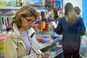 A young woman is shopping in a store in the stationery department