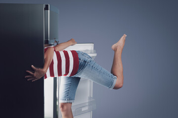Woman with her head in the fridge