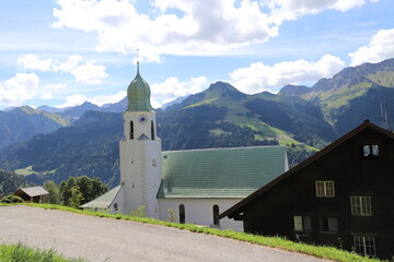 Kirche in Faschin vor Bergkulisse