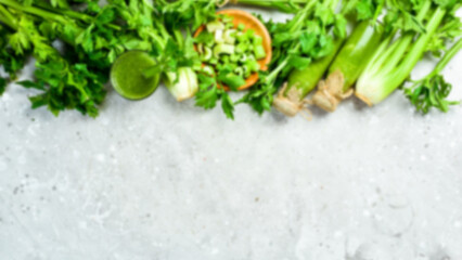 Defocus food banner. Green celery stalk and celery juice on gray stone background. Vegetarian drink. Free space for text.